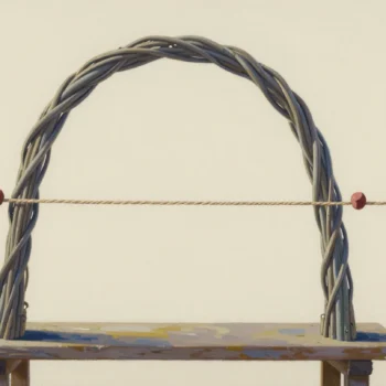 A woven willow arch on a wooden bench with a taut string crossing it at two red-marked points.