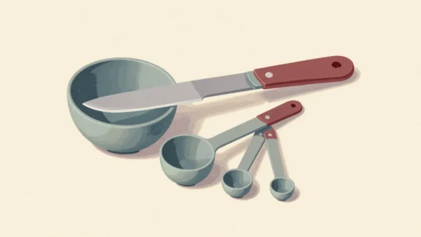 A knife leveling flour in the smallest of a set of measuring spoons