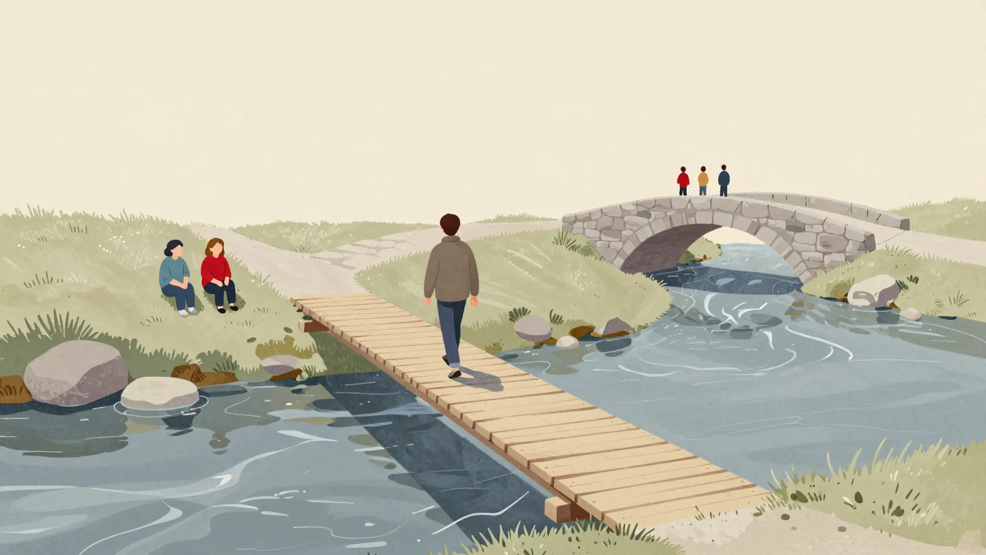 A narrow footbridge with one walker crossing and two waiting on the bank, a wider stone bridge further downstream