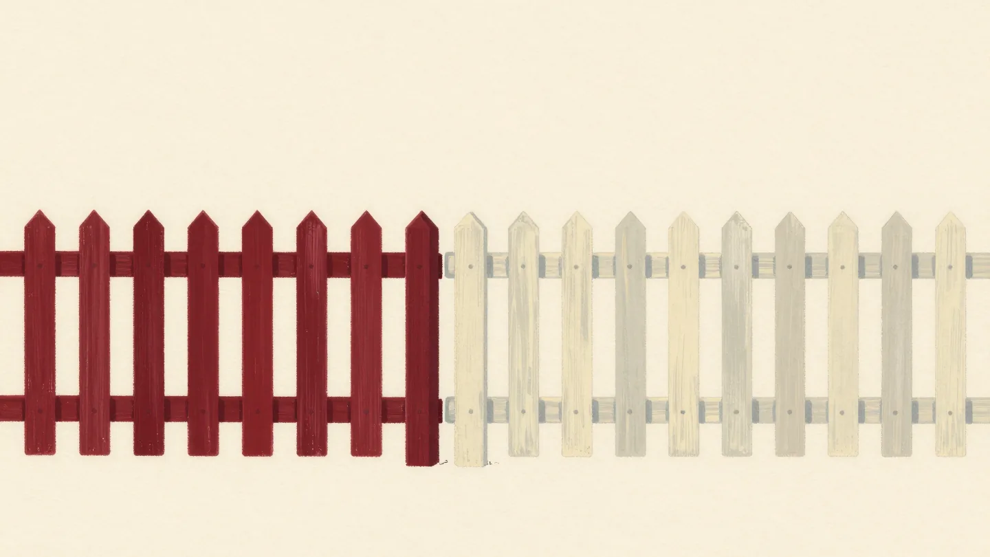Two picket fence sections meeting at one shared post, one painted vermilion, one cream, with no gap between them.