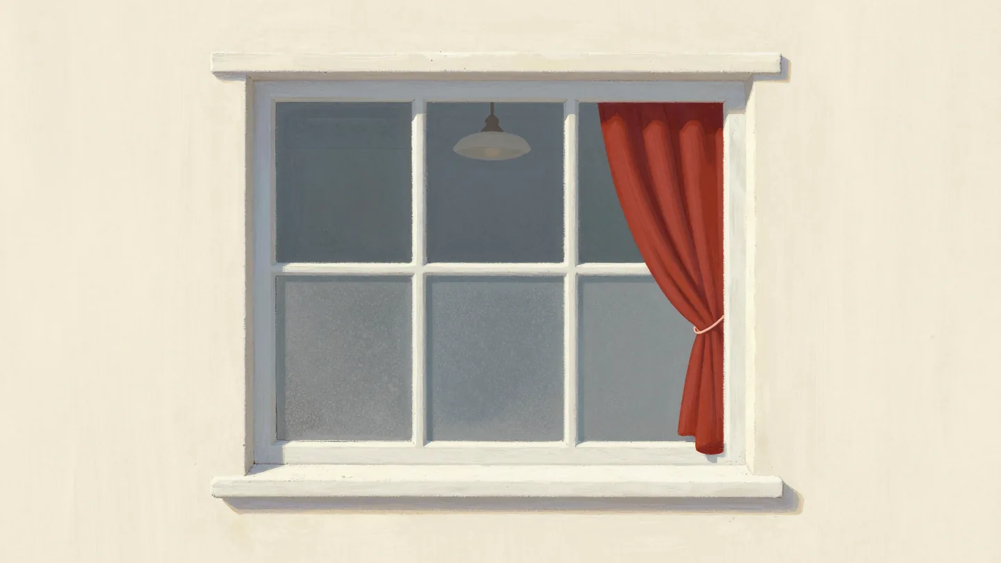 A cottage window frosted on the lower half, clear above, a red curtain tied back