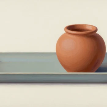 A rounded terracotta pot in a long shallow blue-gray ceramic tray.