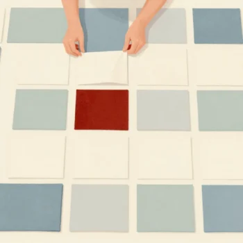 Hands arranging fabric squares into a patchwork quilt pattern