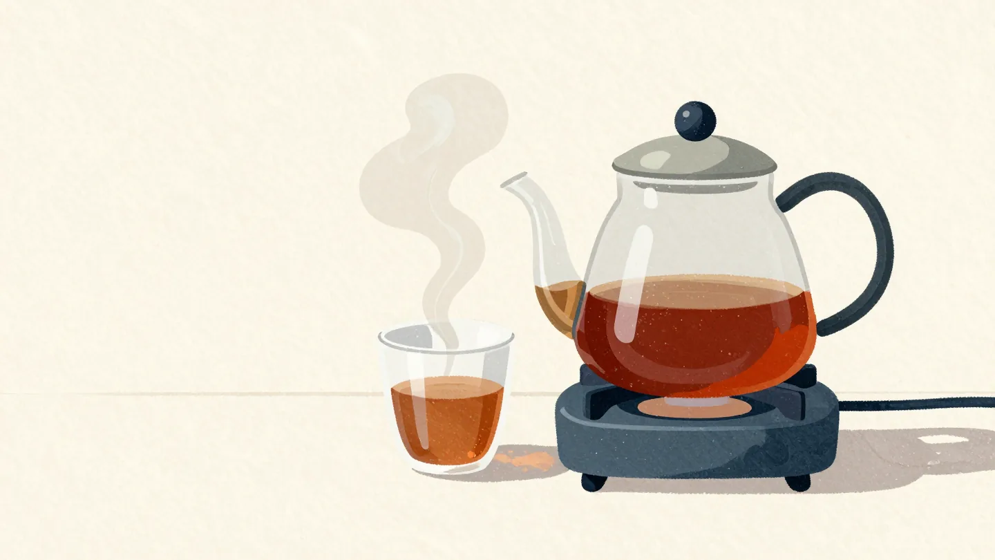 A glass coffee pot on a hotplate in a quiet diner, one freshly poured cup beside it with a thin wisp of steam.