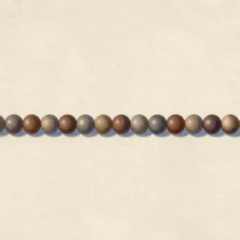 A long cord of wooden beads tied to a brass ring, every seventh bead red, a fingertip on the first