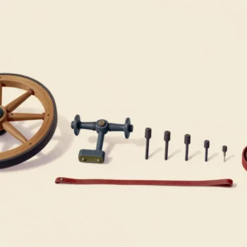 An old spinning wheel taken apart and laid out on a workshop floor in rows from largest part to smallest.