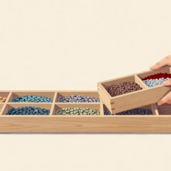 A long wooden seed drawer with equal compartments, two hands lifting one out whole while an empty one waits at the end.