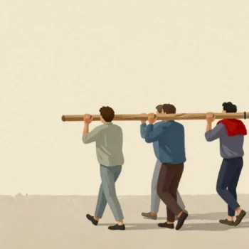 Four figures seen from behind carrying one long oak beam on their shoulders along a village lane.