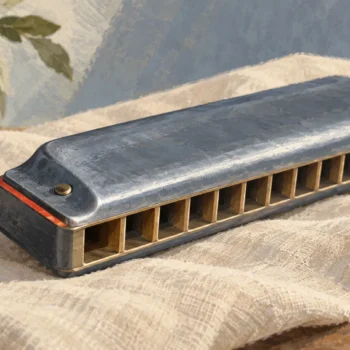 A harmonica exposes separate chambers from one end, with a small vermilion accent on its casing
