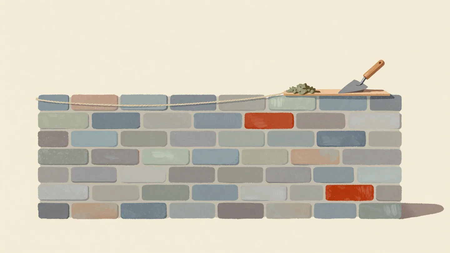 A half-built brick wall with even mortar joints, a taut string line along the top and a trowel on the last brick.