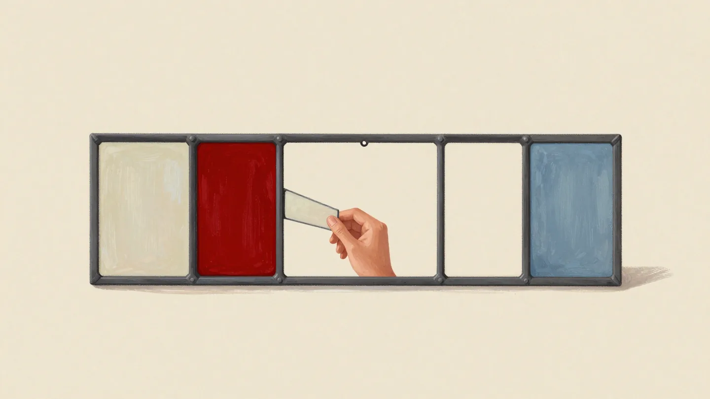 A stained glass panel being made, five panes in a row with two filled and a hand testing a piece in a gap.