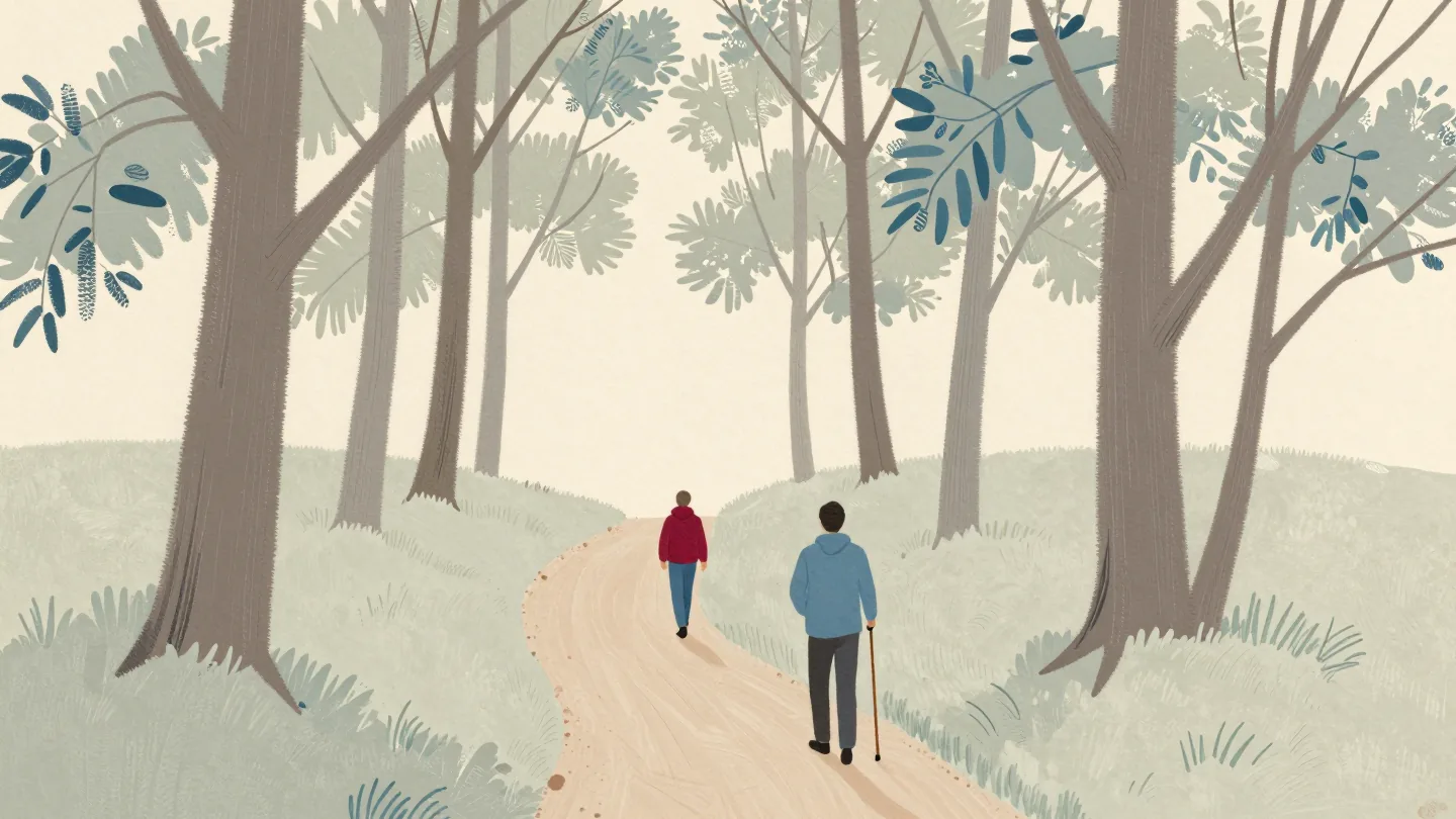A walker seen from behind pauses where a woodland footpath splits into a narrow path and a wider one.