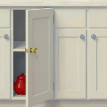 A row of kitchen cupboard doors, one knob worn to bare brass and the paint around it rubbed pale.