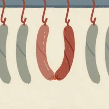 Sausage links on a red hook, one missed twist leaving two sausages joined into one long one