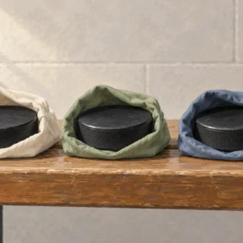 Identical hockey pucks sit in open sleeves of three different colors.