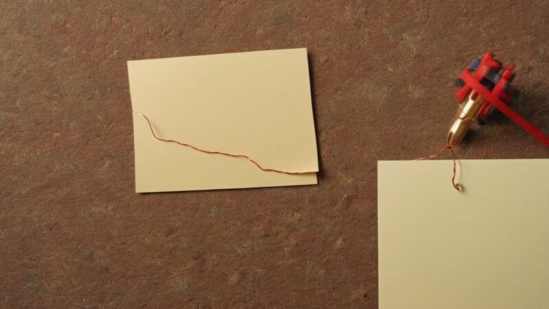 Red thread connecting notes pinned on a cork board, tracing data lineage