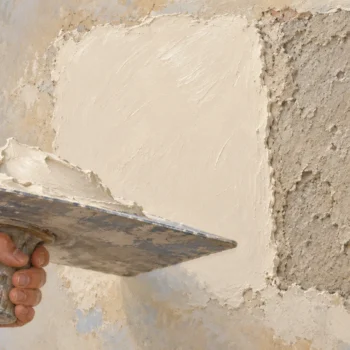 A plaster hawk beside one freshly plastered wall patch and one unchanged patch