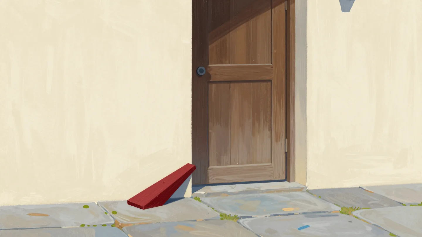 A heavy door propped open by a red wedge that has quietly slid across the floor.