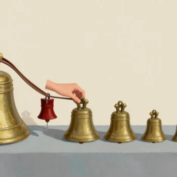 A hand muffling the clapper of one handbell with a leather pad in a row of brass handbells