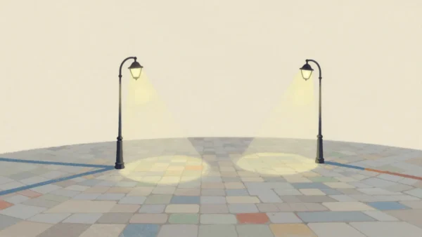 Two street lamps on a cobbled square at night whose pools of light overlap in one brighter patch