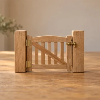 A small wooden gate fitted securely between two plain wooden blocks on a warm tabletop.