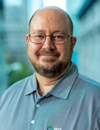 A smiling man with glasses and a beard.