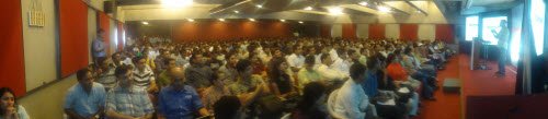 Panoramic view of attendees at a tech conference.