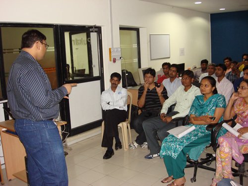 Man pointing to whiteboard during meeting.