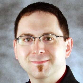 A man in glasses smiling.