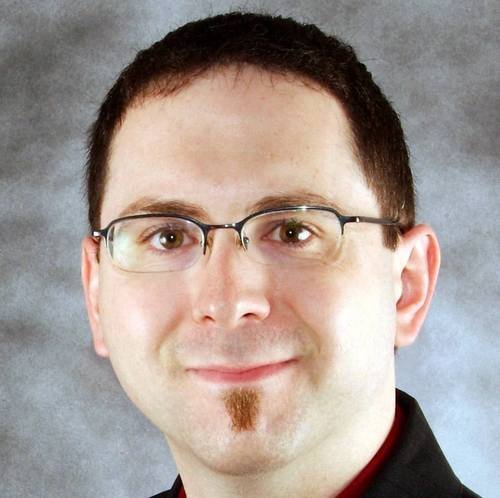 A man in glasses smiling.