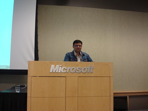 SQL Server conference speaker at Microsoft podium.