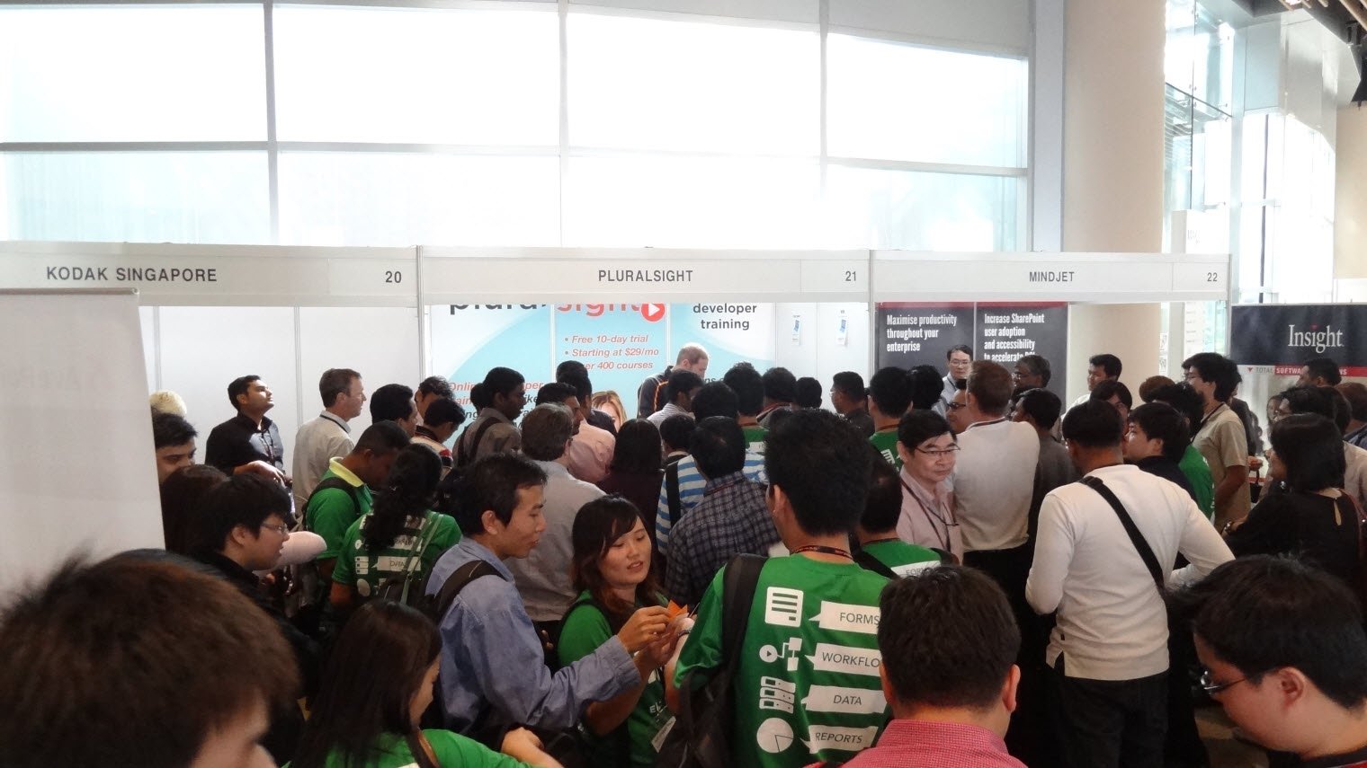 A crowd of attendees gathered in the exhibition area of the conference