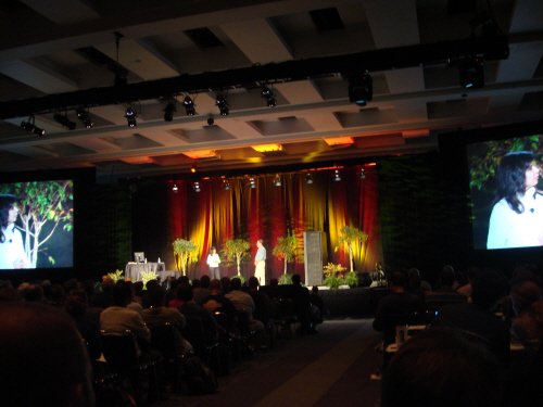 Conference with large audience in auditorium.