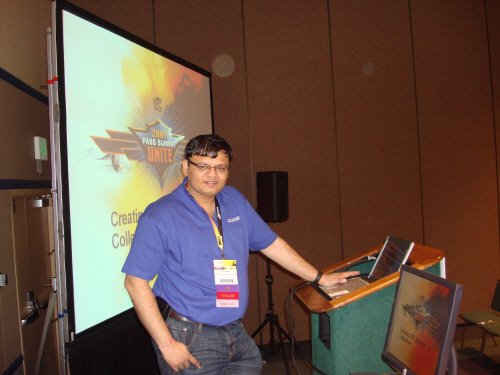 A man at a lectern with a presentation screen.