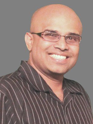 A smiling man with glasses.