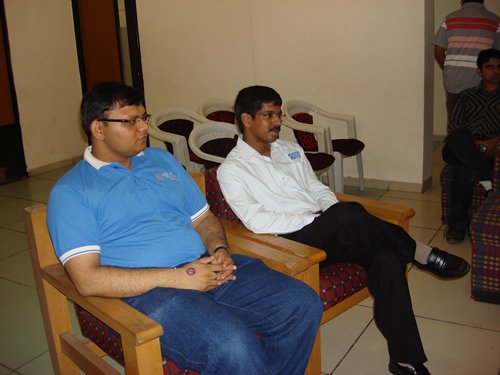 A classroom full of attendees and a speaker at the front.