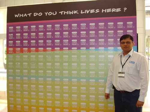Person in front of colorful 'Lives Here' sign at TechEd India 2009.