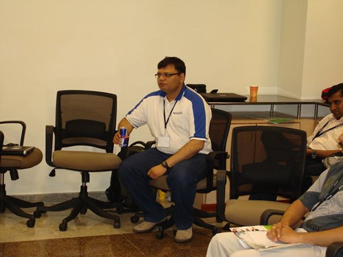 Man in blue and white shirt holding a can.