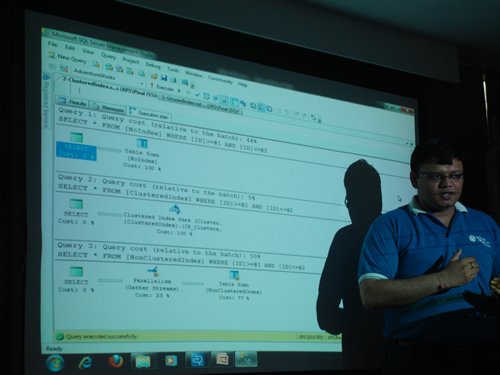 Person giving a technical presentation with child in arms.