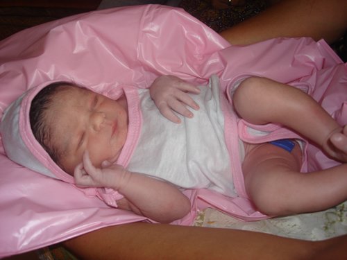 Newborn baby in pink blanket.