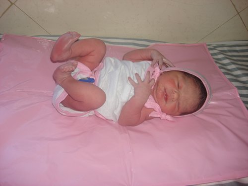 Newborn baby on pink blanket.