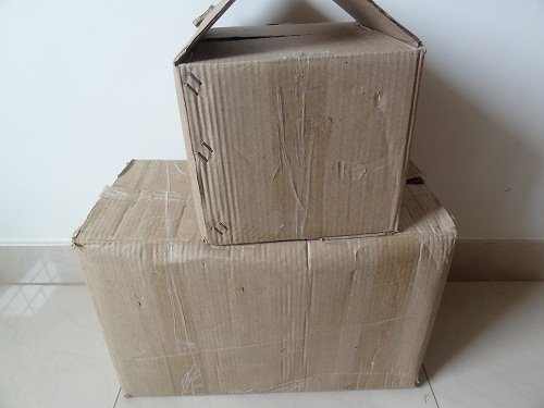 Two cardboard boxes on a floor.
