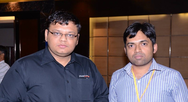 Two men standing in a conference room.