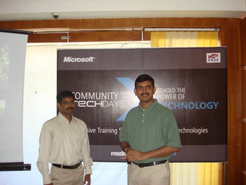 Two men shaking hands in front of a Microsoft banner.