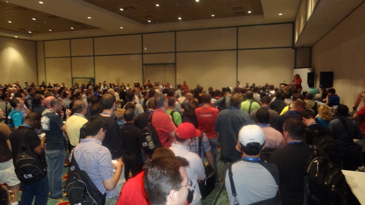 Conference attendees with speaker on stage.