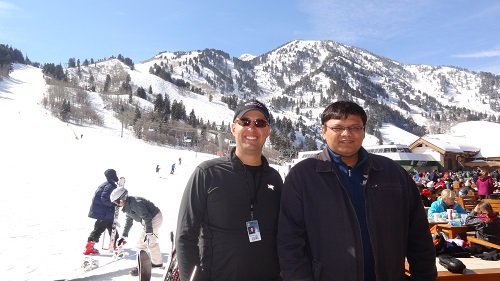 Two men posing for a photo at a ski resort.