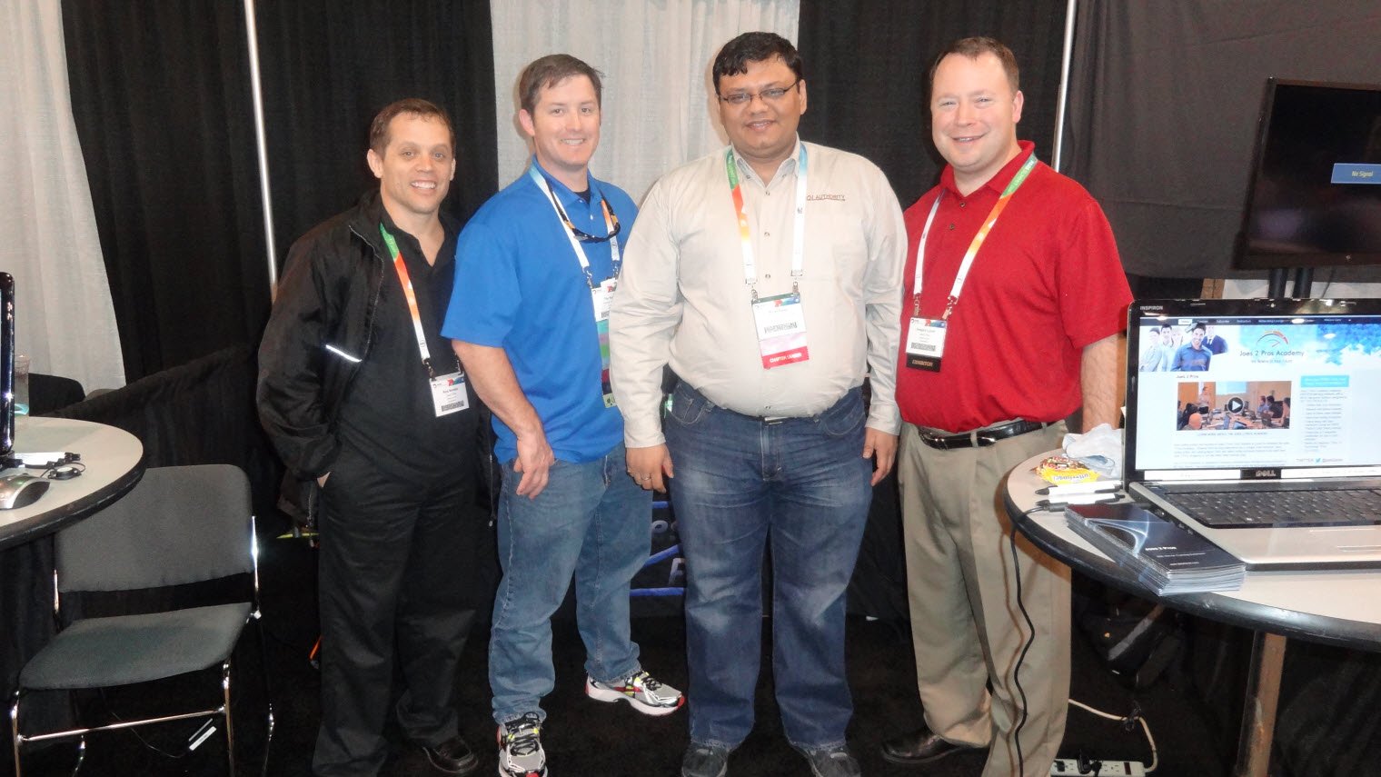 Four men posing for photo at tech conference.
