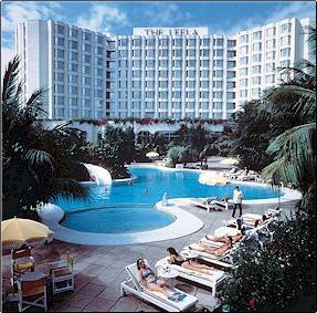 Aerial view of a hotel with a large swimming pool.